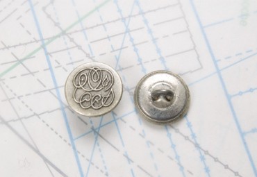 Bouton en métal argenté noirci estampé boucle en U insérée