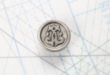 Bouton en métal argenté noirci estampé boucle oméga